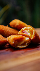 Jakarta, 30 June 2025 : Frozen breaded spring rolls with kaffir lime leaves on wooden background....
