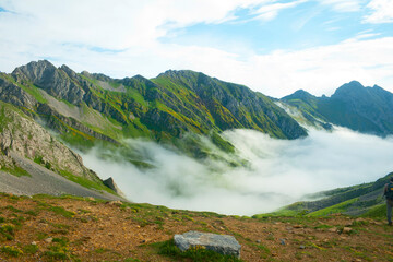 Valley surrounded by mountains covered in fog at dawn
