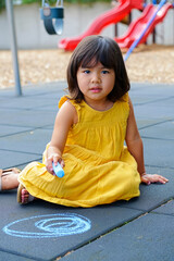 Young girl in yellow dress draws with chalk on asphalt, demonstrating creativity, playfulness in the fresh air. AI generated.
