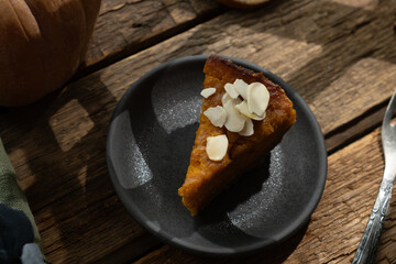Slice of pumpkin pie sprinkled with sliced almonds. Homemade traditional American thanksgiving pie