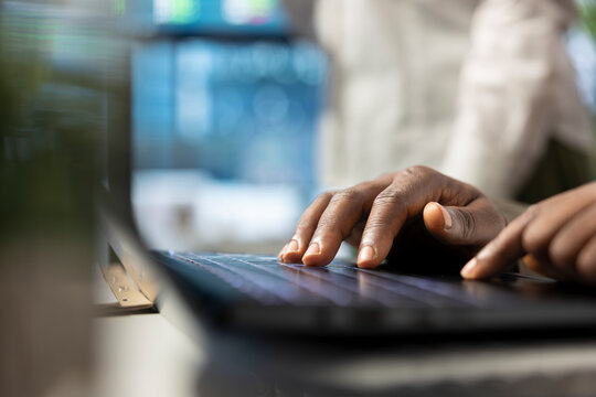 Team leader creating a financial projection during a meeting with his staff, working on the new project for business expansion. Investor taking notes on his laptop in boardroom. Close up.