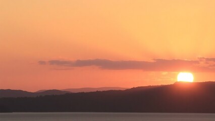 Obraz premium Serene Sunset over Silhouetted Hills A Peaceful Landscape Photography