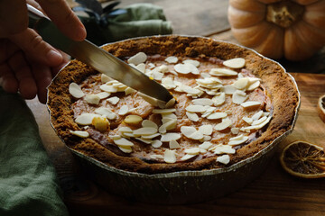  Cutting Pumpkin Pie Sprinkled with Almonds. Homemade cooking thanksgiving pie