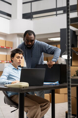 Team of diverse workers reviewing custom orders in a distribution hub filled with taped boxes on shelves or racks, People representing a local brand small scale logistics center.