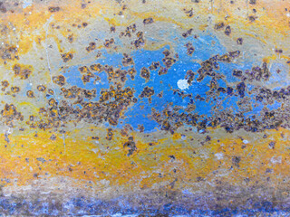 Rust on metal. Old blue paint and corrosion spots are visible. Yellow, brown, red colors of...