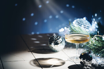 Christmas and New Year celebration with champagne. New Year holiday decorated table. Festive New Year champagne and silver baubles. Close up. Christmas greeting card with copy space.