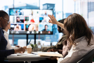 Diverse team of workers reviewing project updates together with shareholders on video call online...
