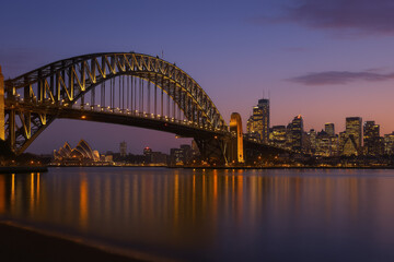 Naklejka premium Sydney harbor bridge and opera house at dusk with city skyline view