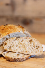 Homemade freshly bread and slices on kitchen table. Sourdough wheat rye loaf with seeds close-up view
