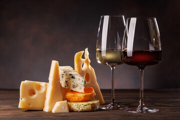 Assorted cheeses paired with glasses of wine on a rustic table
