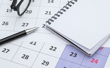 A calendar, pen and planner are lying on the desk, planning