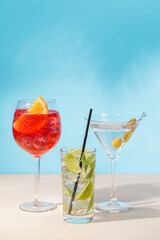 A variety of cocktails arranged on a table against a light blue background