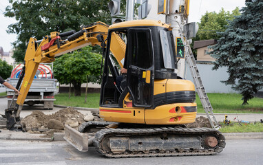 Excavator at work in urban setting performing road maintenance during daytime