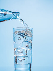 Crystal clear water being poured into a transparent glass, creating refreshing ripples and bubbles