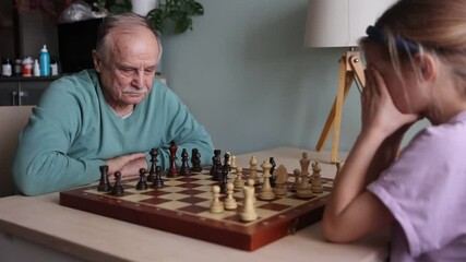 grand parent with granddaughter play chess together at home. Quality Time. Family having fun playing at home - Powered by Adobe