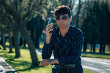 young man on his electric scooter looking at his mobile phone