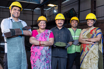 Worker standing in the factory. Group Staff Standing In Engineering Factory. Diverse multiethnic...