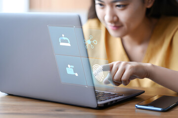 Young woman using laptop with futuristic fingerprint security interface; modern technology, digital security, online privacy concept.