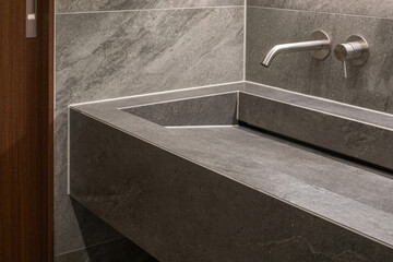 The high-end interior bathroom is stylish with a recessed faucet that shines