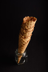 Waffle cones arranged vertically in a glass jar stand ready to be filled with ice cream, perfect...
