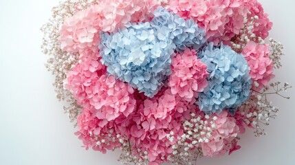 This stunning bouquet features light blue and light pink hydrangeas surrounded by delicate gypsophila, all arranged in a round milk carton on a white surface.