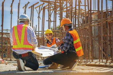 Structural engineer, architect and foreman worker with blueprints discuss, plan working for the outdoors building construction site. Construction collaboration concept