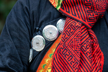 Close up accessories such as jewelry are attached or hung on the traditional costumes of the Tay...