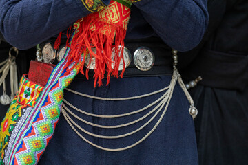 Close up accessories such as jewelry are attached or hung on the traditional costumes of the Tay...