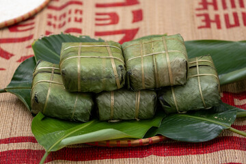 Woman with traditional Tay dress Making (wrapping) Tet Cake, the Vietnamese lunar new year Tet food...