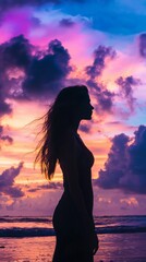 Fototapeta premium A graceful silhouette of a woman stands by the ocean as the sun sets, with vibrant colors painting the sky, creating a serene and reflective atmosphere perfect for conceptual imagery.