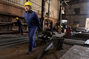 Fototapeta premium Factory worker with cage trolley at factory