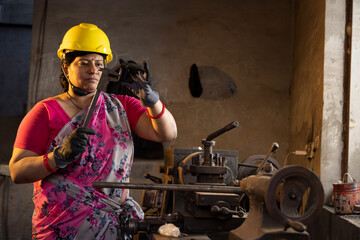 Female maintenance engineer with mechanic measuring using micrometer at workshop