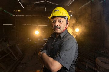 Industrial worker with arms crossed at factory