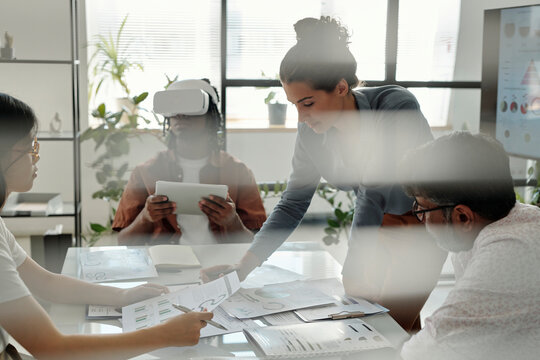 Team collaborating in an office with VR technology and documents