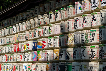 Straw-wrapped sake barrels stacked as offerings at Meiji Jing
