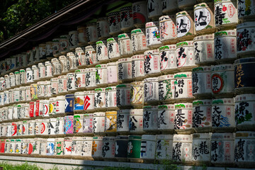 Straw-wrapped sake barrels stacked as offerings at Meiji Jing