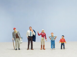 Mini toy of action figure at table with blurred background. Miniature diorama photography concept design. Minifigure showing generations from baby boomers to gen alpha, representing age diversity.