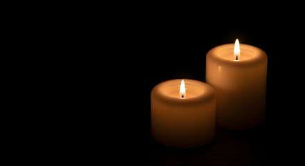 Two burning candles on dark background
