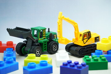 Mini toy of heavy truck and mini figure at table with blurred background. Toy photography concept. Industrial conceptual design.