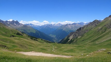 Naklejka premium Panoramic view of a serene mountain valley, showcasing lush green slopes, winding paths, and a clear blue sky. Distant snow-capped peaks add to the breathtaking vista