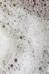 The texture of white foam in water. Vertical shot