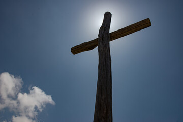 Sunlit cross on top of mountain