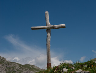 Sunlit cross on top of mountain