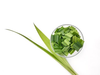 Fresh pandan leaf (Pandanus amaryllifolius) slices in bowl isolated on white background, Flat lay 