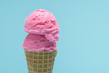 Double Scoop of Pink Ice Cream in a Waffle Cone. Blue background