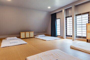 Minimalist bedroom with futon mattress and wooden floor featuring natural light from large windows creating calm atmosphere for rest and relaxation modern space with t cell and cancer research
