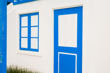 Charming Blue Door and Window on White Wall - Evokes Mediterranean Village Atmosphere