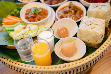 Traditional food basket with eggs vegetable and drinks arranged on banana leaf for healthy meal...