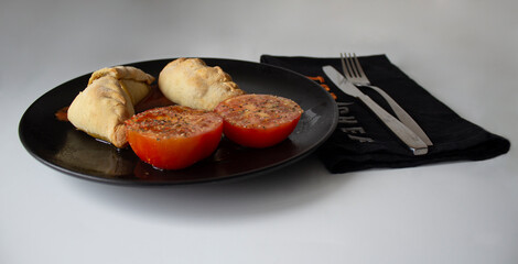 Delicious tuna empanadas, stuffed with tuna, bell pepper, tomato, hard-boiled egg and olives; served with tomato, olive oil, garlic, and oregano.