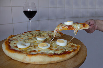 Delicious ham pizza with melting mozzarella cheese and hard-boiled egg